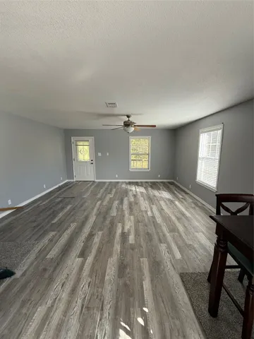 a view of an empty room and window and wooden floor