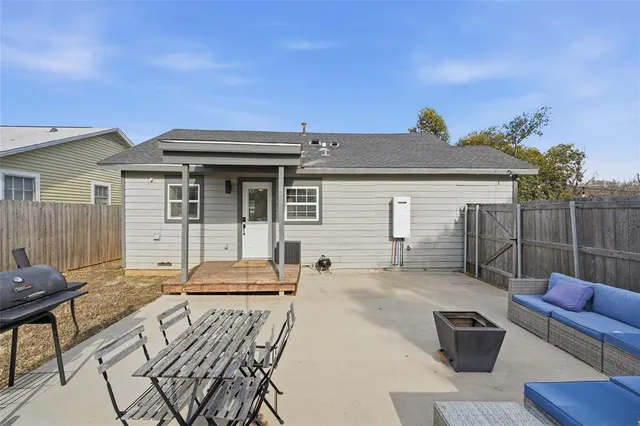 a backyard of a house with wooden fence and large trees
