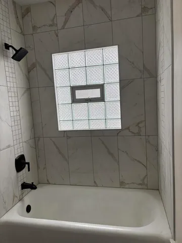 a bathroom with a bathtub and a shower