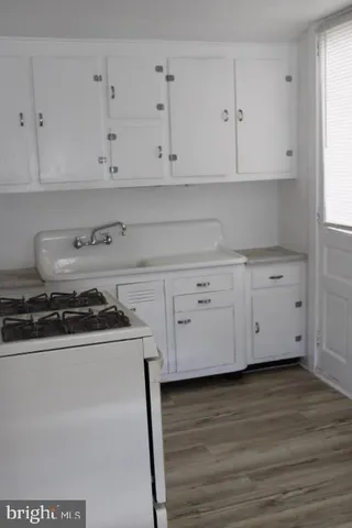a kitchen with white cabinets and appliances