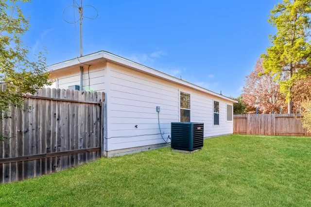 a backyard of a house with barbeque oven and wooden fence