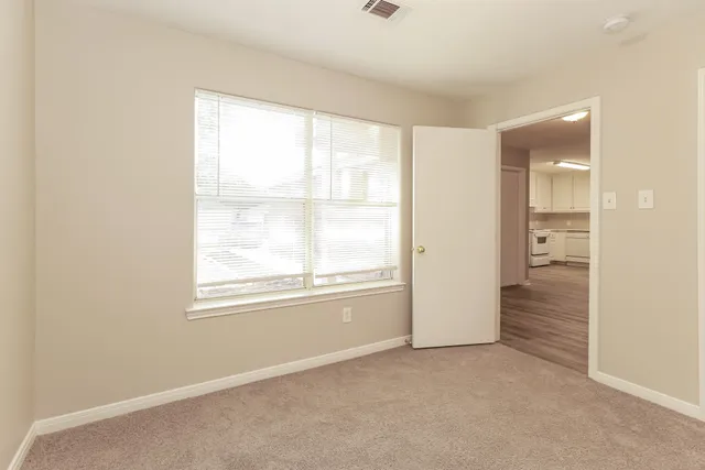 an empty room with windows and closet