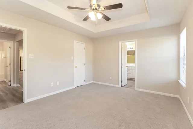 an empty room with closet and a chandelier fan