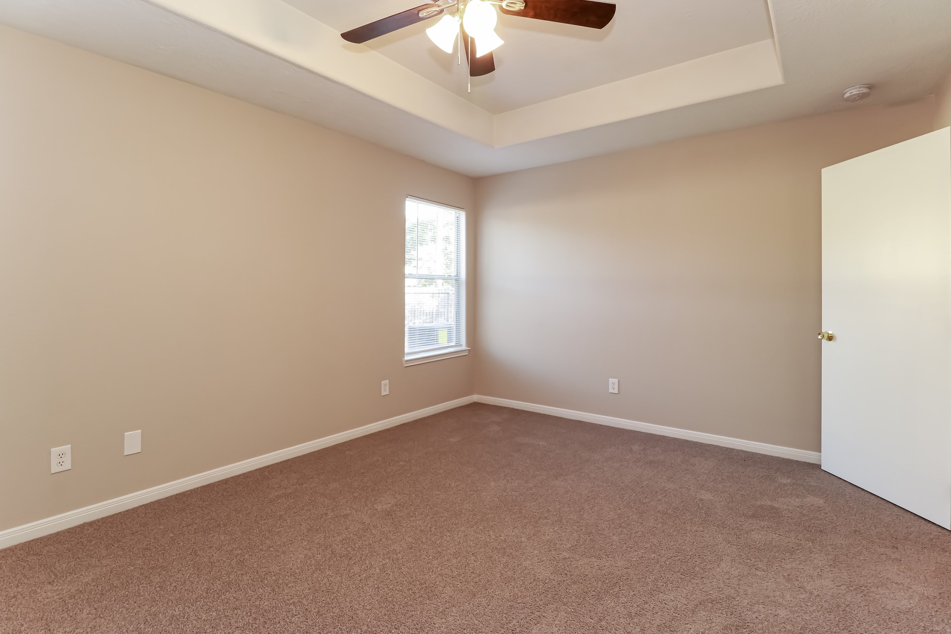 16360 Hidden River Court Conroe, TX 77302 - Photo 10 of 16 an empty room with a chandelier fan and windows