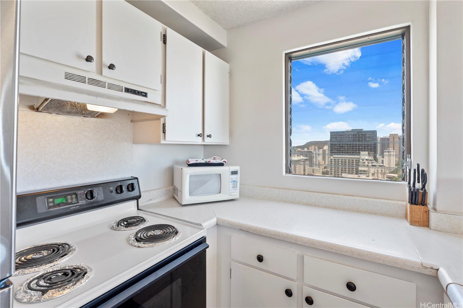 2240 Kūhiō Avenue, Unit 2308 Honolulu, HI 96815 - Photo 5 of 21 a kitchen with a stove and a refrigerator