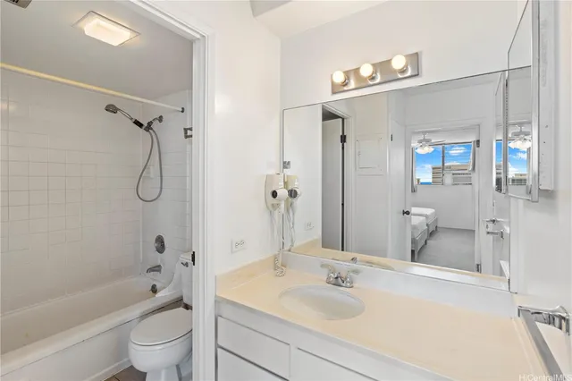 a bathroom with a granite countertop sink a toilet and shower