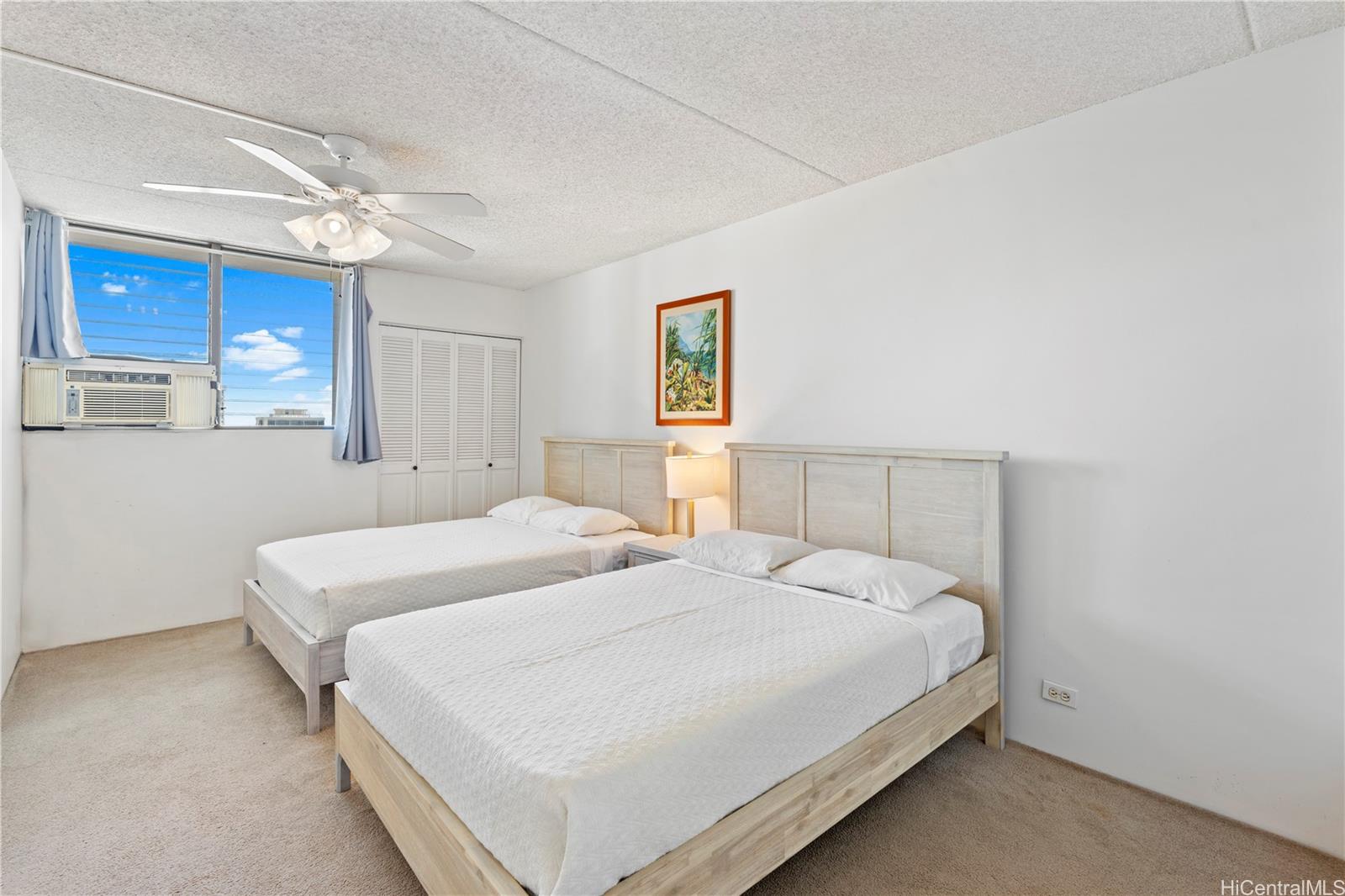 2240 Kūhiō Avenue, Unit 2308 Honolulu, HI 96815 - Photo 9 of 21 a bedroom with a large bed and a chandelier
