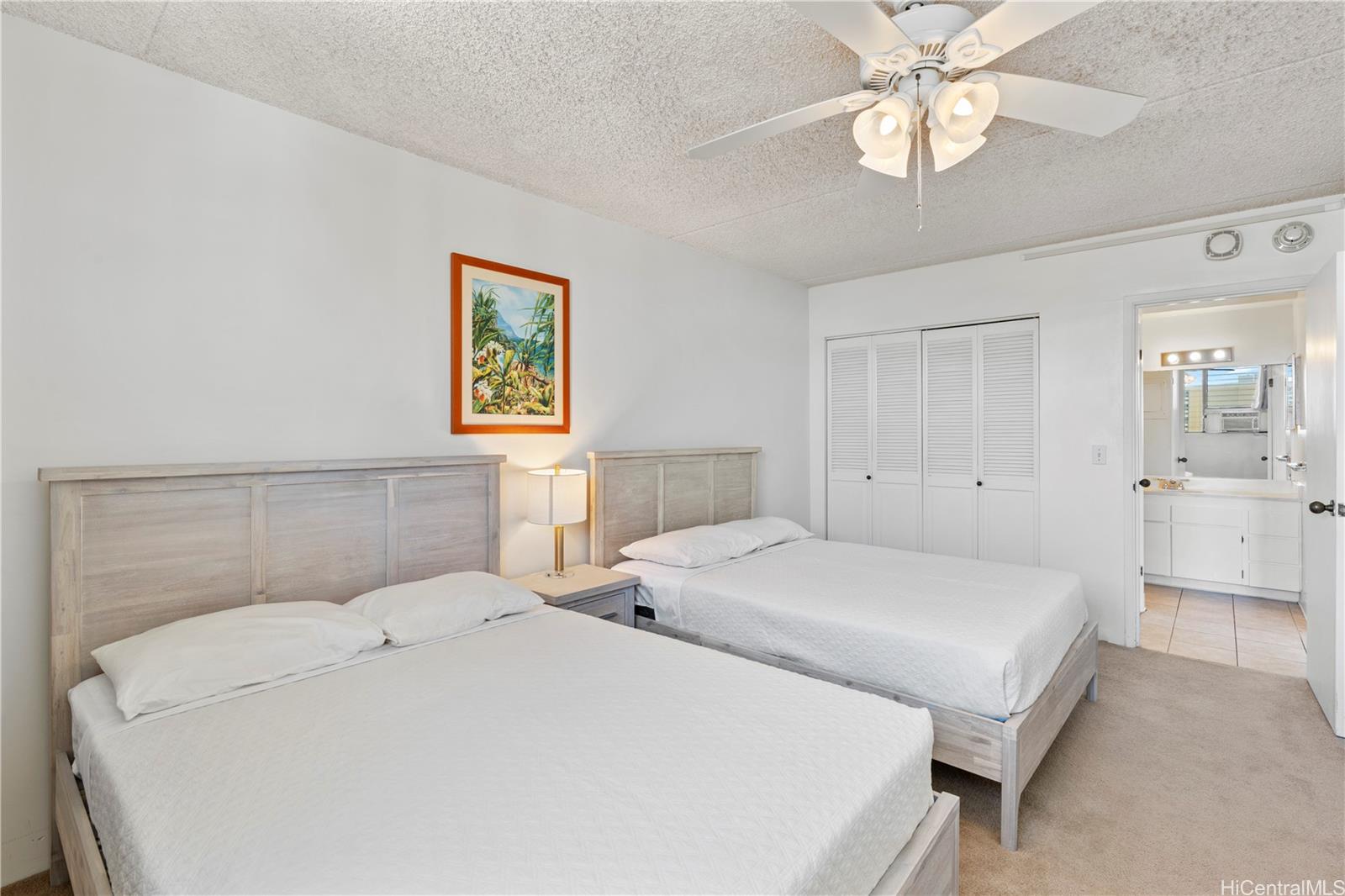 2240 Kūhiō Avenue, Unit 2308 Honolulu, HI 96815 - Photo 10 of 21 a spacious bedroom with a bed and a chandelier