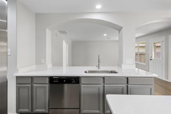 a kitchen with a sink refrigerator and cabinets