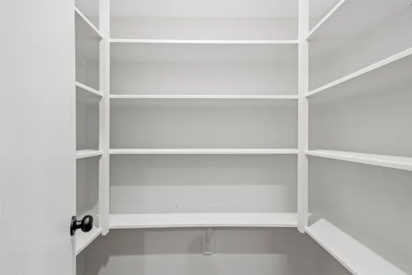 a view of walk in closet with empty racks