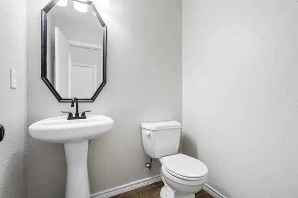 a bathroom with a toilet a sink and a mirror