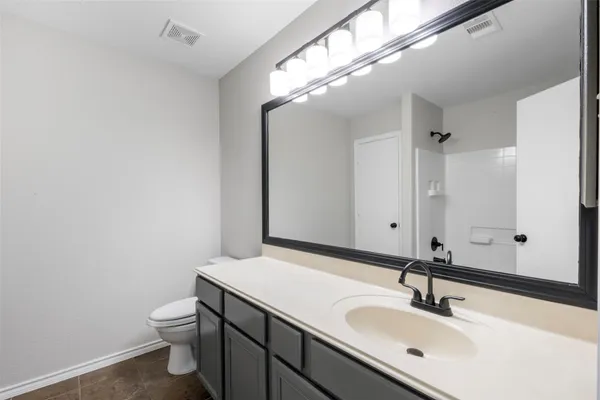 a bathroom with a sink a toilet and a mirror