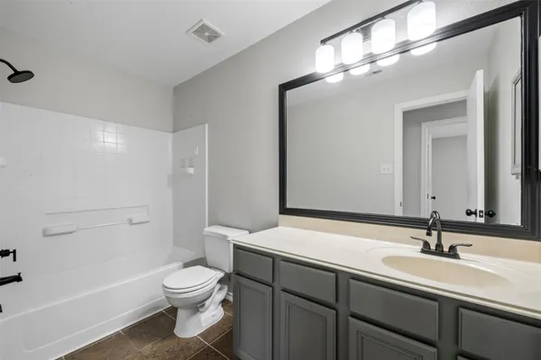 a bathroom with a toilet a sink and a large mirror
