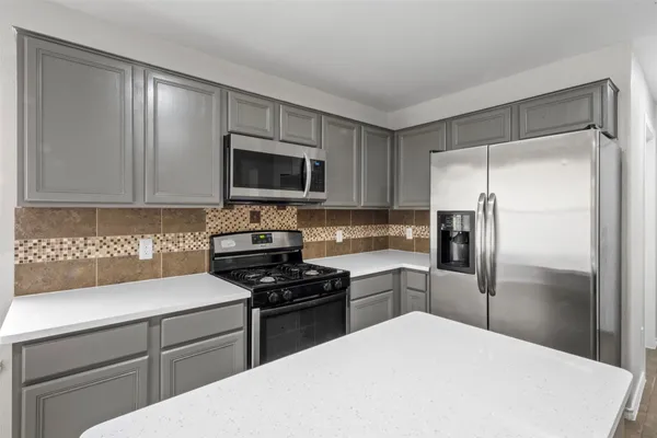 a kitchen with a refrigerator stove and microwave