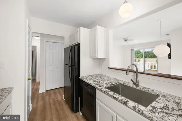 a kitchen with granite countertop a refrigerator and a sink