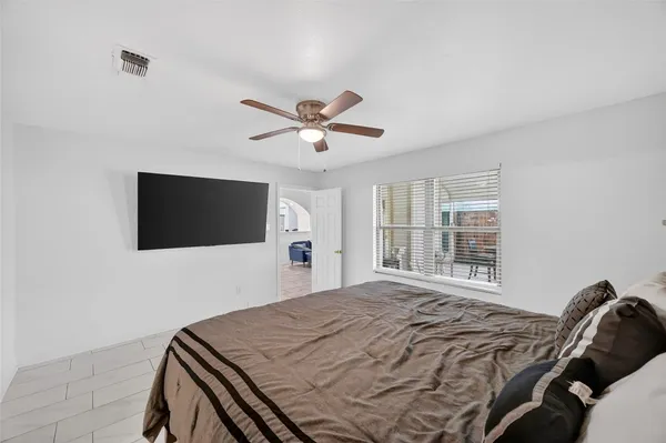 a bedroom with a bed and a large window