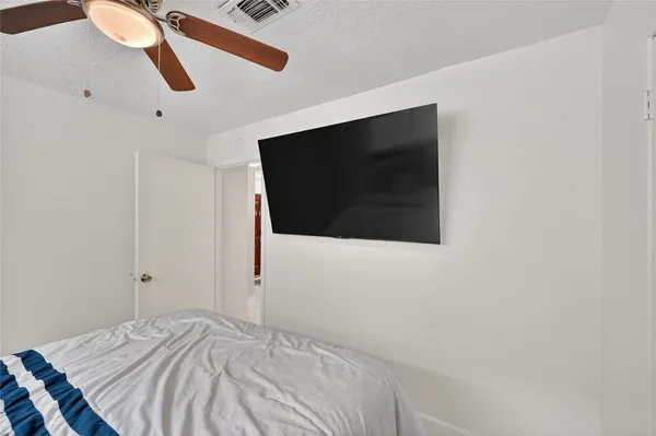 a bedroom with a bed and a flat screen tv