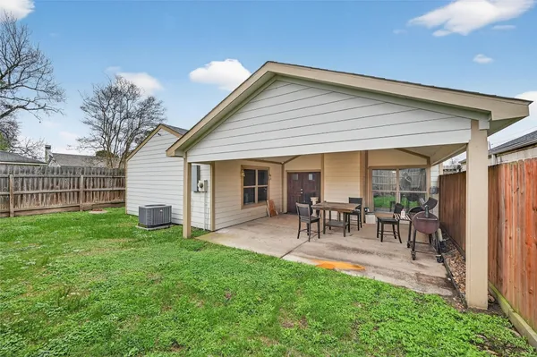 a view of a house with a backyard and chairs