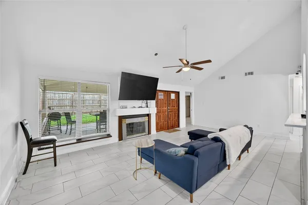 a living room with furniture a fireplace and a flat screen tv