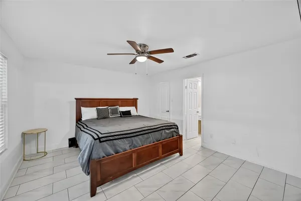 a bedroom with a bed and a ceiling fan