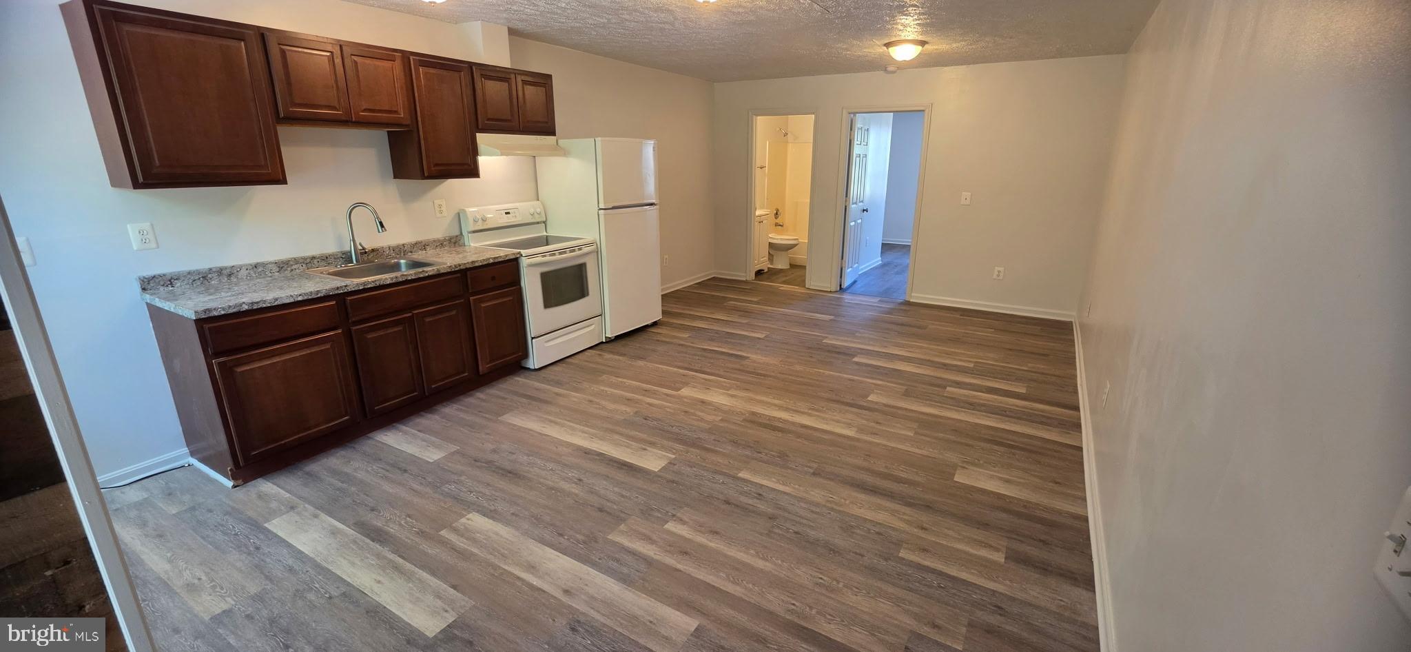 a kitchen with stainless steel appliances granite countertop a refrigerator and a stove top oven