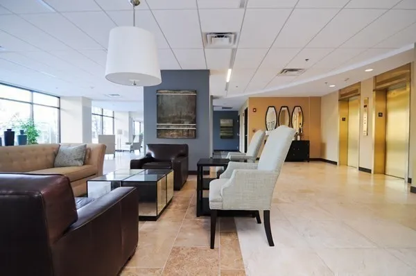 a living room with furniture a flat screen tv and a chandelier