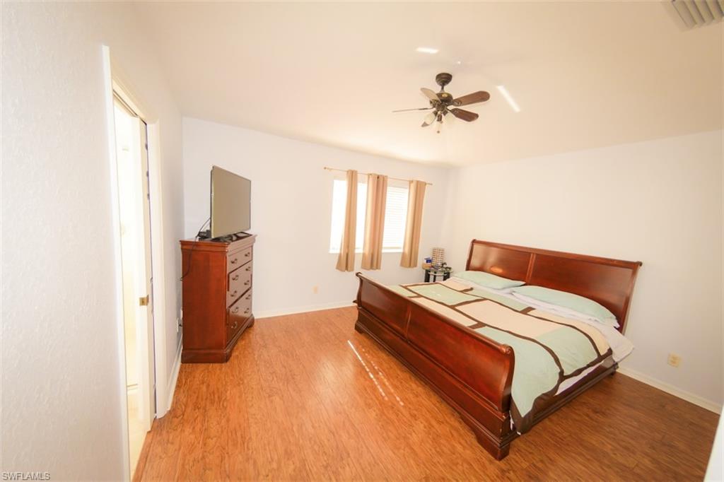 17537 Cherry Ridge Lane Fort Myers, FL 33967 - Photo 11 of 20 a bed room with a bed and a chandelier