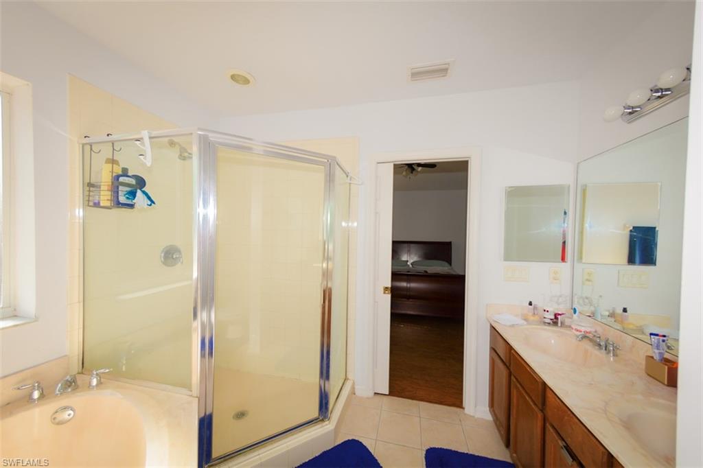 17537 Cherry Ridge Lane Fort Myers, FL 33967 - Photo 15 of 20 a bathroom with a tub sink and mirror