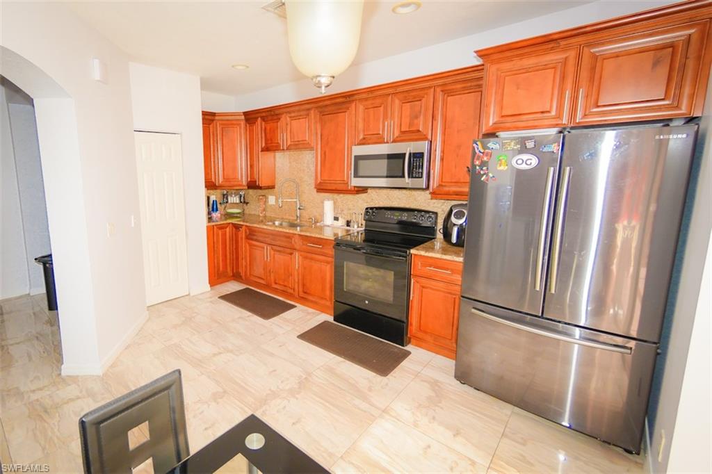17537 Cherry Ridge Lane Fort Myers, FL 33967 - Photo 7 of 20 a kitchen with stainless steel appliances granite countertop a refrigerator stove microwave and sink