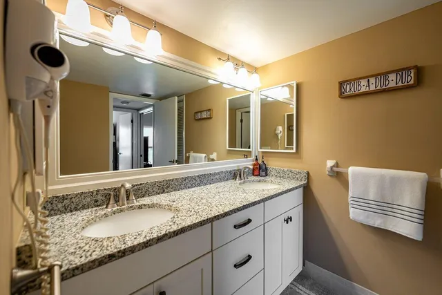 a bathroom with a granite countertop sink and a toilet