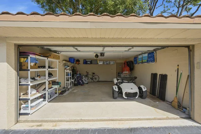 a aerial view of a house with pool lawn chairs and large trees