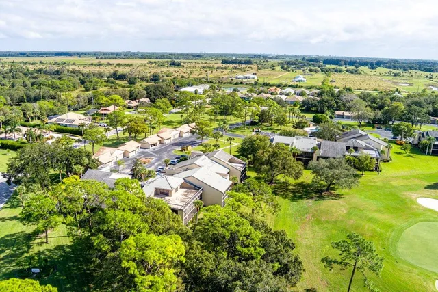 an aerial view of a house with a garden and lake view