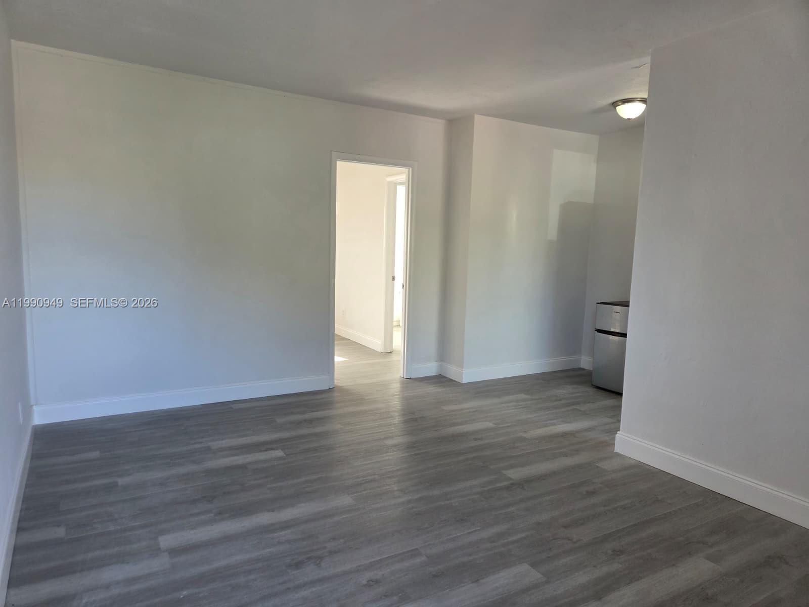 1628 Southwest 7th Street, Unit 8 Miami, FL 33135 - Photo 6 of 8 a view of an empty room with wooden floor and a window