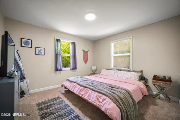 a bedroom with a bed desk and a window