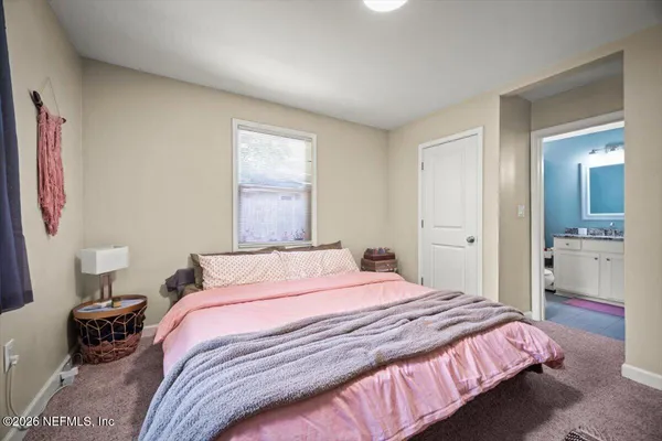 a bedroom with a bed and a view of bathroom