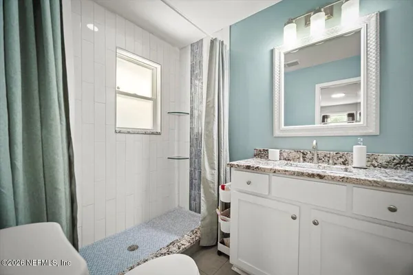 a bathroom with a granite countertop sink toilet and shower