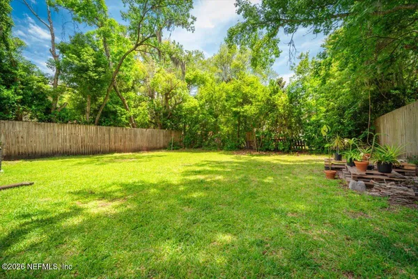 a view of yard with swimming pool and trees in the background