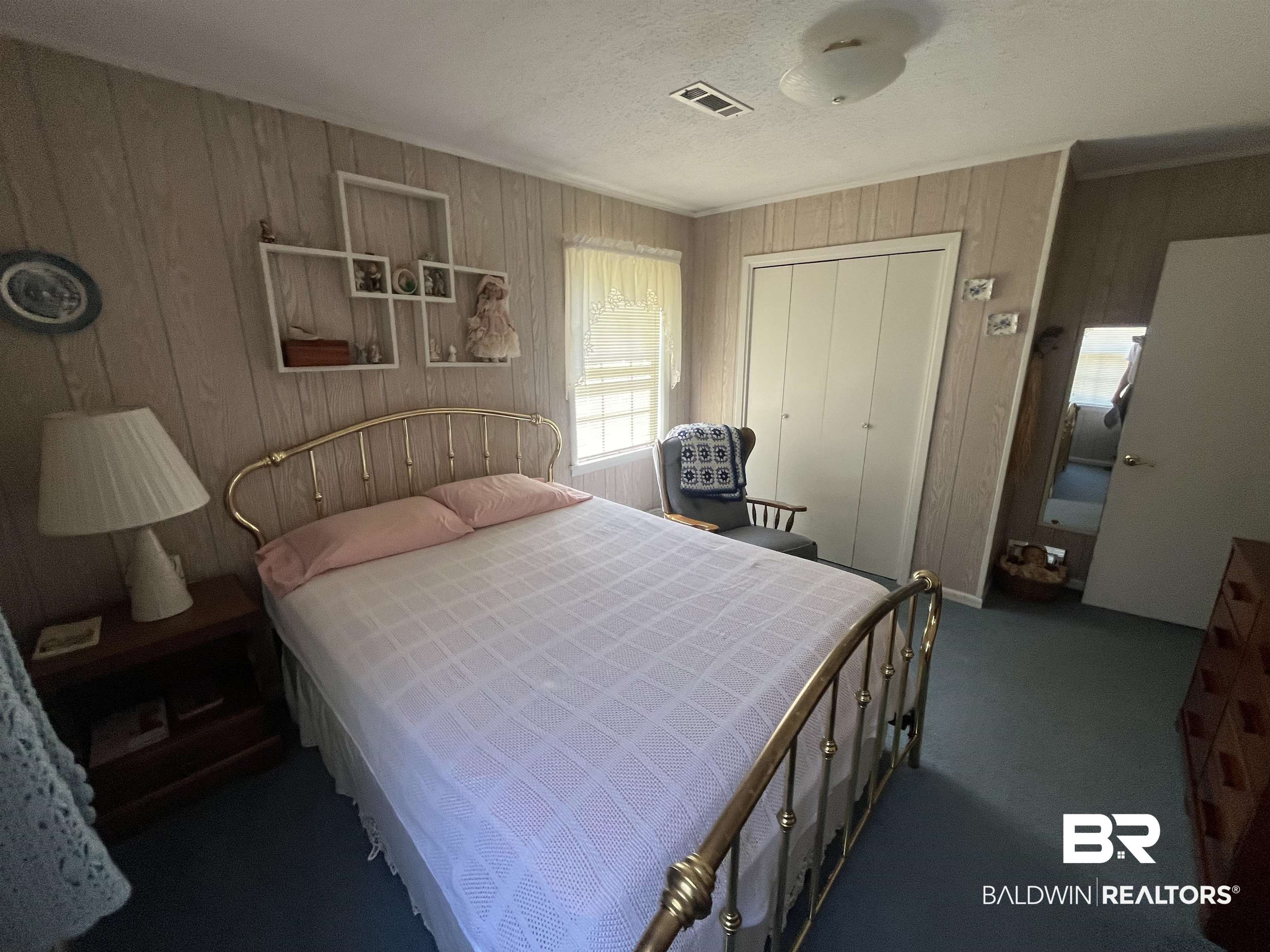 315 Dawkins Road Brewton, AL 36426 - Photo 16 of 19 Carpeted bedroom featuring ornamental molding, wooden walls, visible vents, and a closet