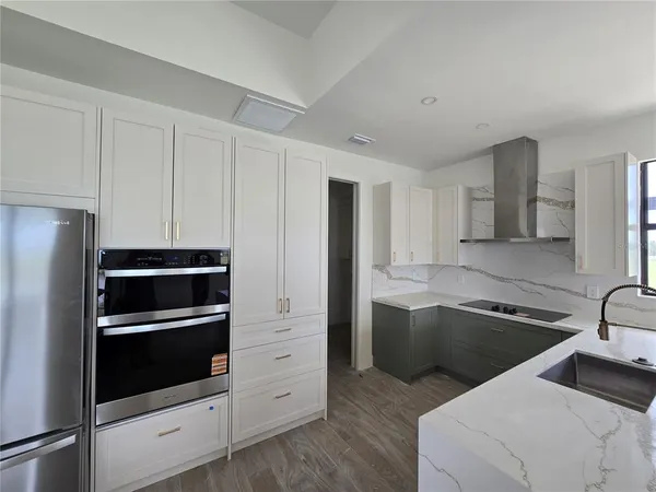 a kitchen that has a sink cabinets and stainless steel appliances