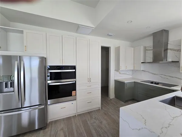 a kitchen with cabinets stainless steel appliances and wooden floor