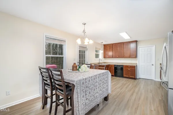 a view of a a dining room with furniture window and wooden floor