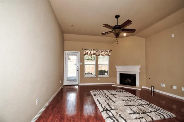a living room with a fireplace furniture a rug and a window