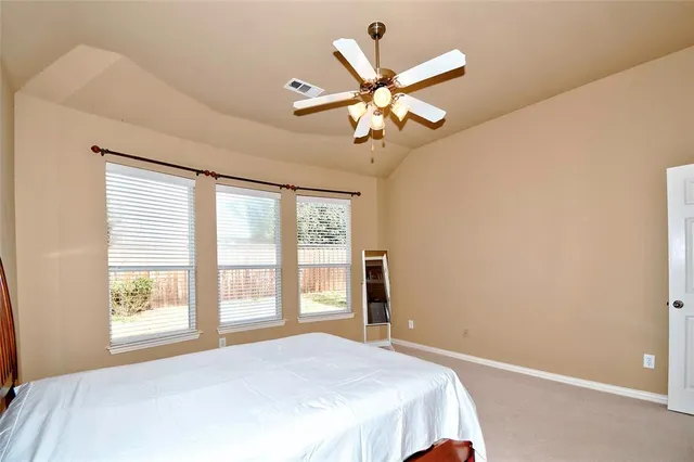 a bedroom with a large bed and a window