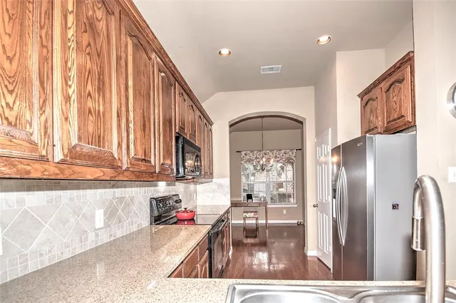 a kitchen with stainless steel appliances granite countertop a refrigerator and a sink