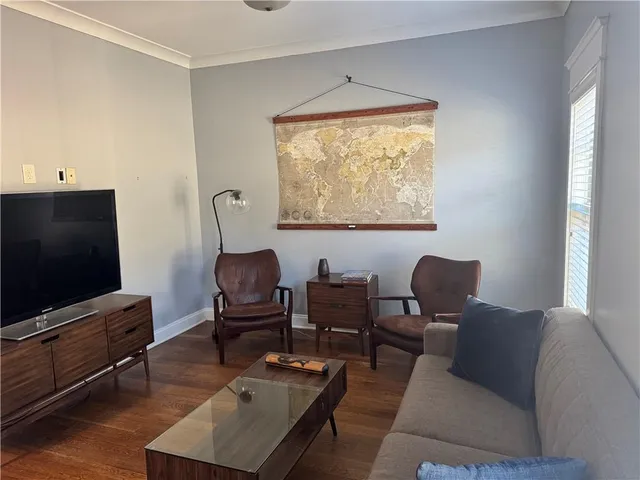 a living room with furniture a window and a flat screen tv