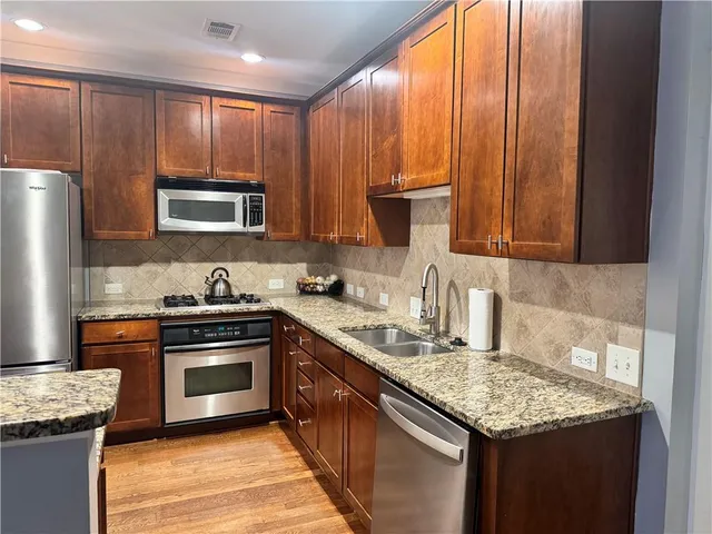 a kitchen with granite countertop stainless steel appliances and wooden cabinets