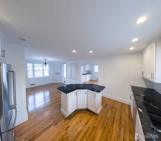 a kitchen with granite countertop a stove a sink and a microwave