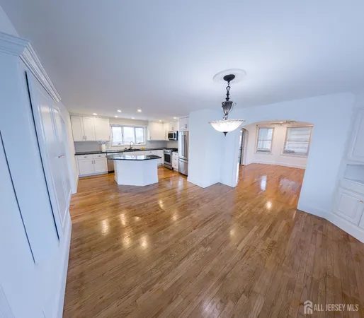 a view of a room with wooden floor and a ceiling fan