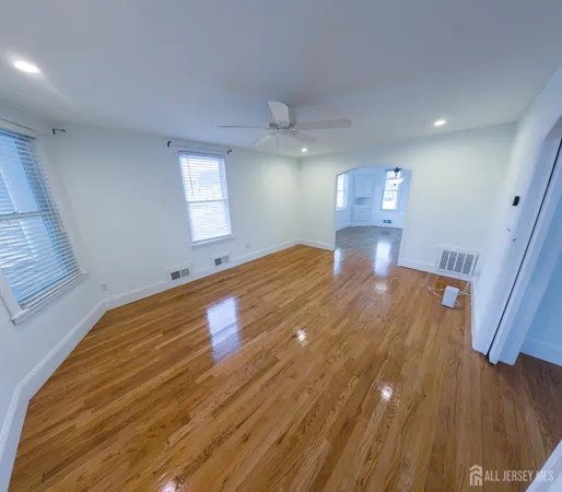 a spacious bedroom with a bed and wooden floor