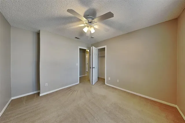 a view of an empty room with a ceiling fan